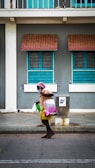 A friendly aide helping an elderly man with his shopping bags outside a store