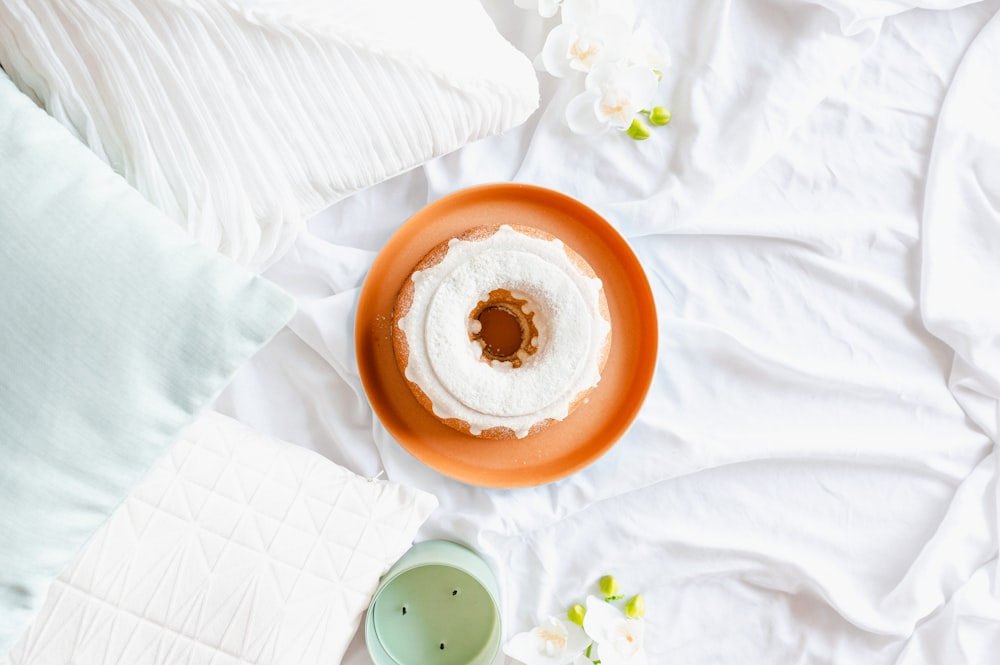 orange and white round ornament on white textile