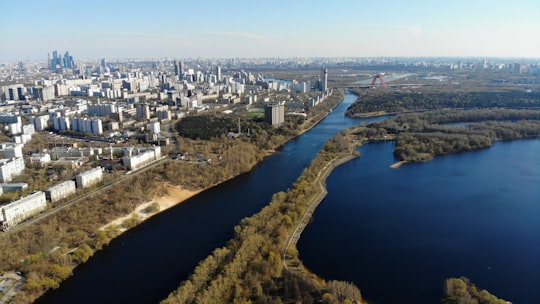 aerial view of city buildings and river during daytime in Strogino District Russia