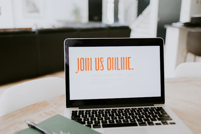 MacBook Pro on a brown wooden table showing Join us online