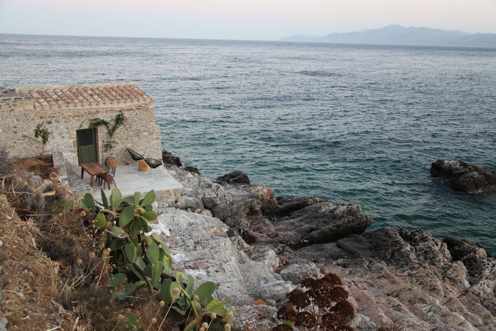 brown concrete house near body of water during daytime