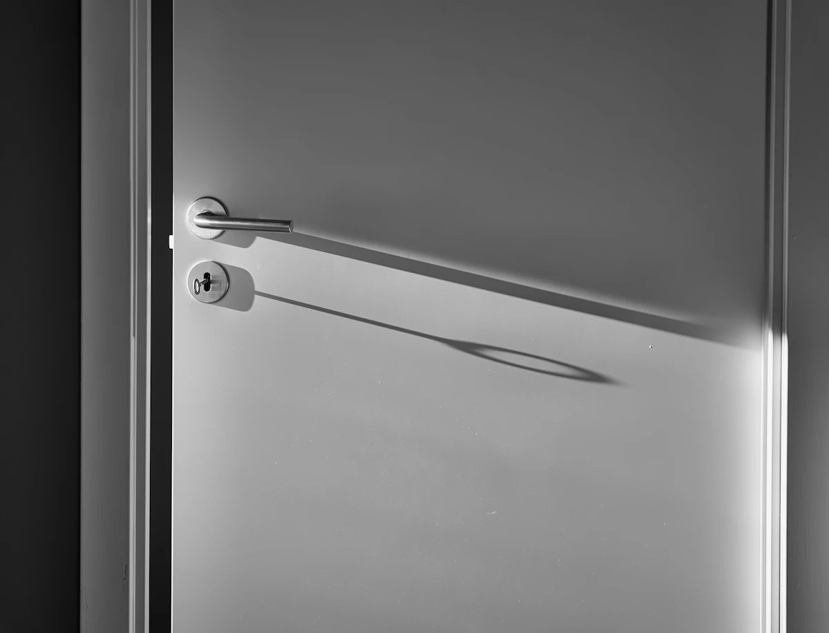 White interior door with silver lever handle in a bright rental bedroom