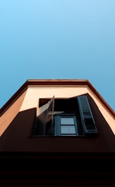 A friendly technician repairing a window shutter on a sunny day.
