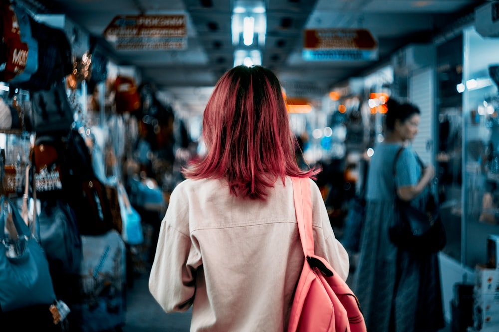 woman in white coat walking on street during nighttime