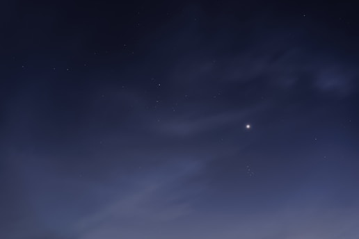 A serene image of a person consulting ancient astrology charts under a starlit sky.