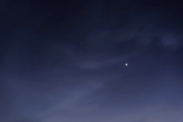 A serene night sky with a few bright stars, emphasizing calm and simplicity.