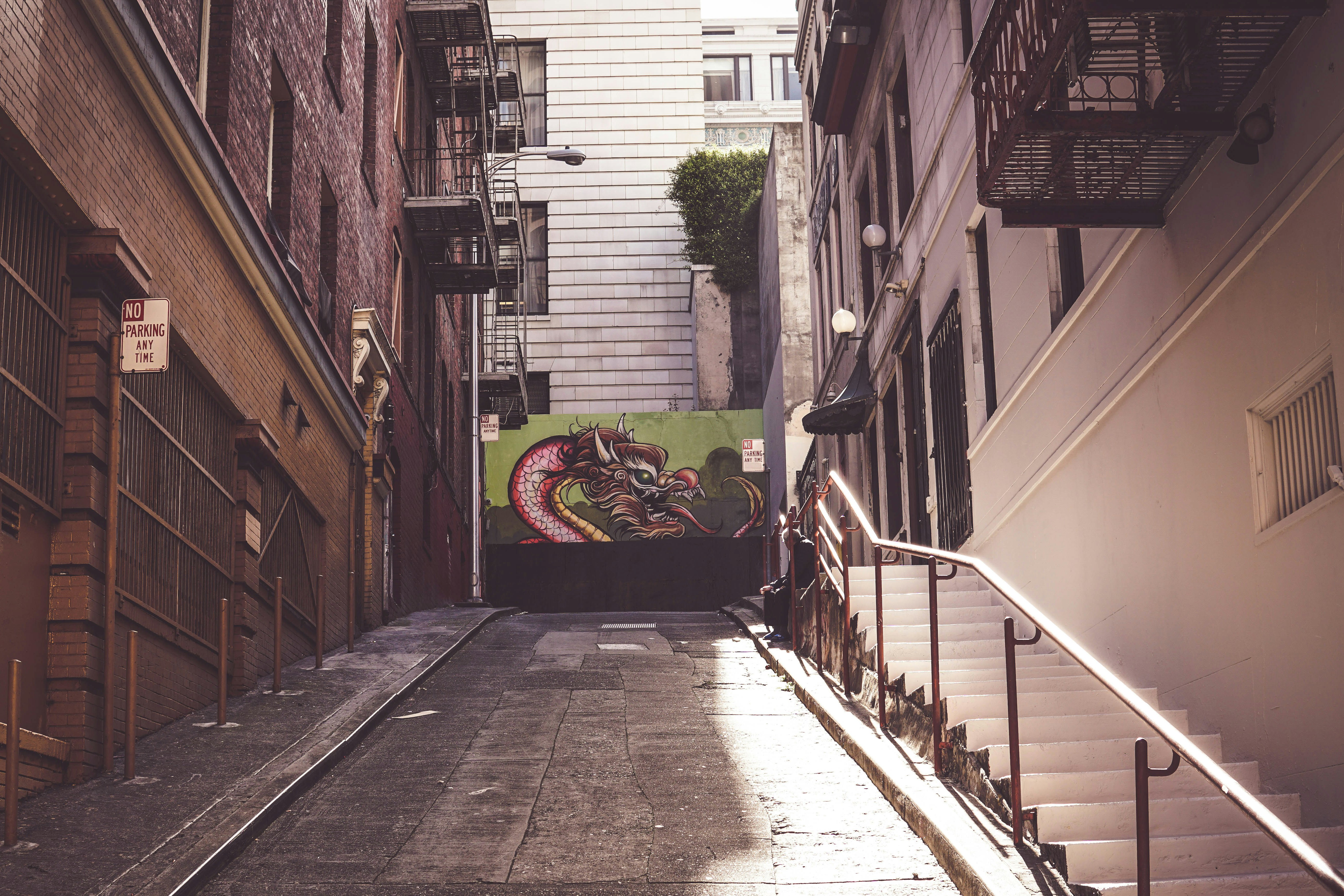 brown brick pathway between houses during daytime