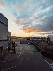 A dynamic aerial view of a bustling international airport runway at sunset, highlighting ongoing construction and aircraft activity.