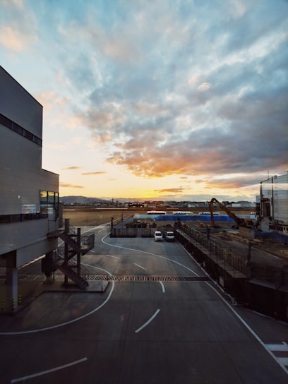 A dynamic aerial view of a bustling international airport runway at sunset, highlighting ongoing construction and aircraft activity.