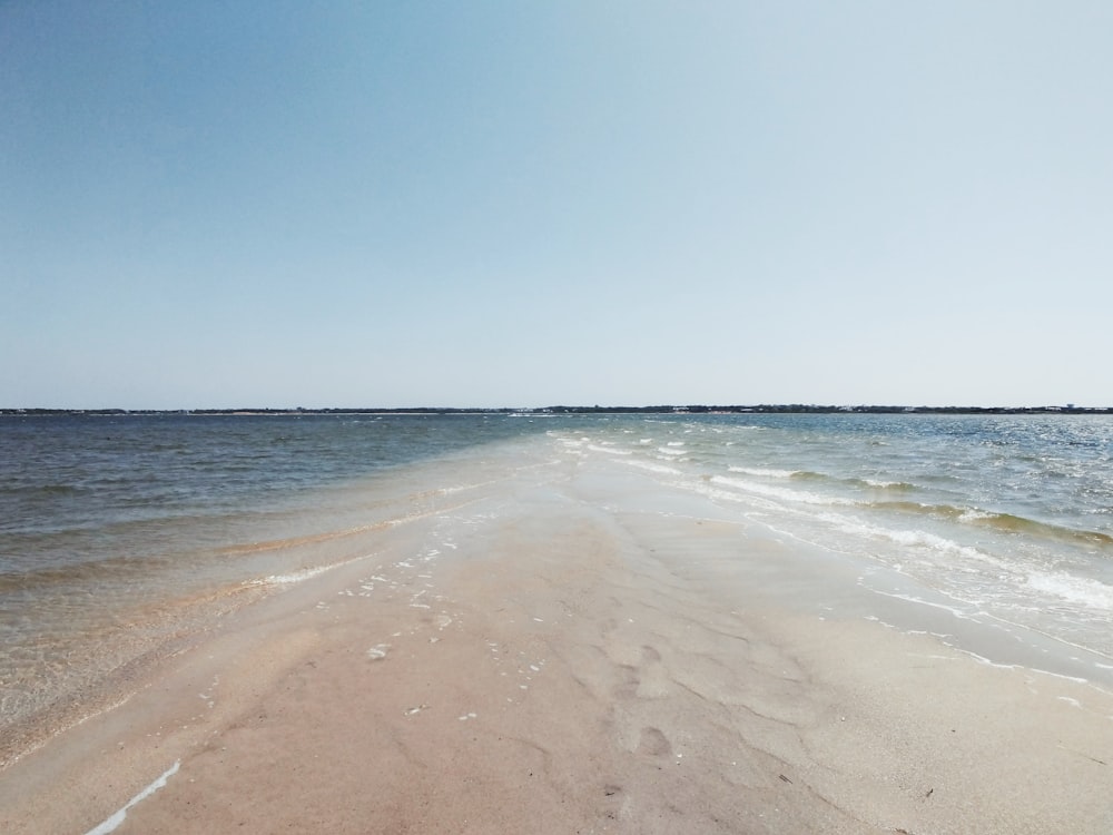 brown sand beach under blue sky during daytime