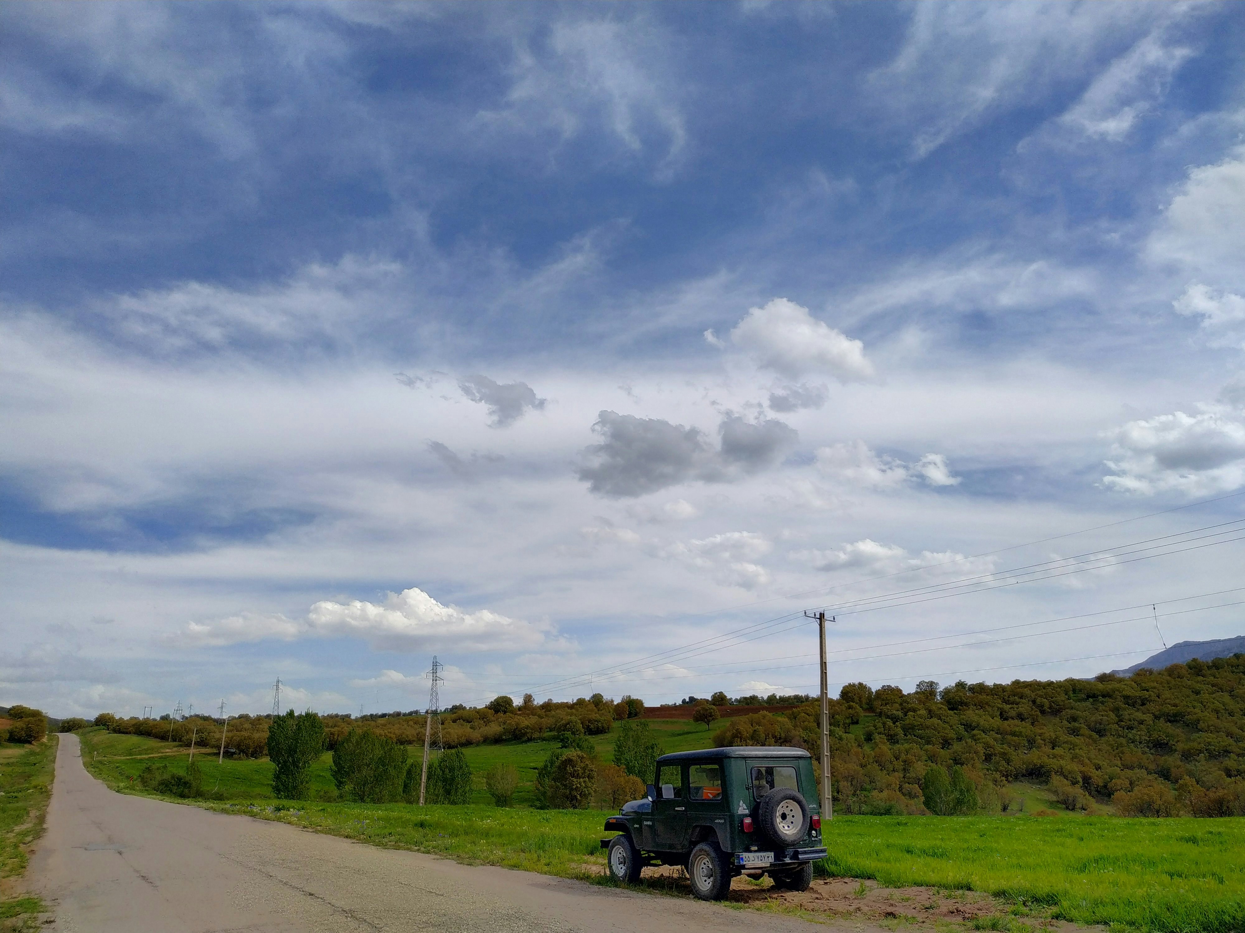 Camion bleu et noir sur la route sous un ciel nuageux pendant la journée