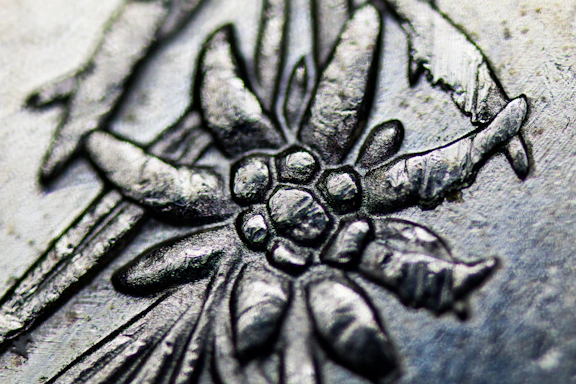 Close-up of a custom laser-engraved wooden sign with delicate floral details.