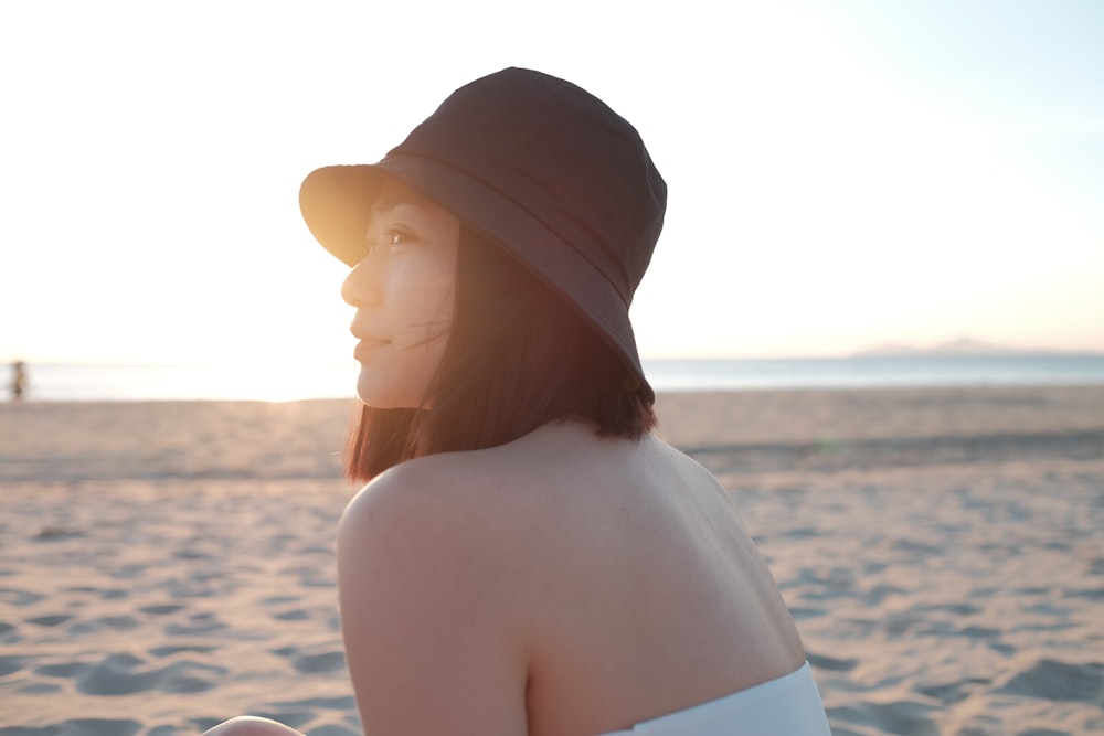 woman in white knit cap on beach during daytime