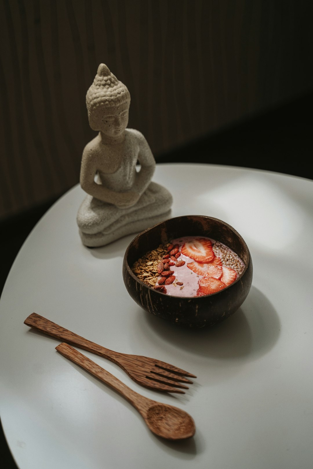 white ceramic figurine beside black ceramic bowl