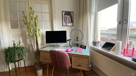 A cozy home office setup featuring a sleek laptop, smart home devices glowing softly, and a vibrant deep crimson accent wall.