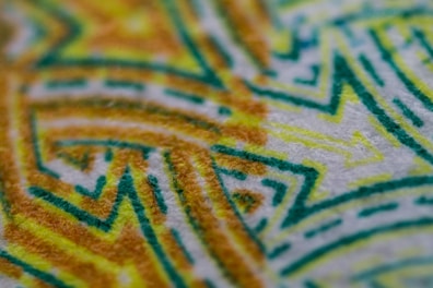 A close-up of a hand-painted fabric design with artistic patterns.
