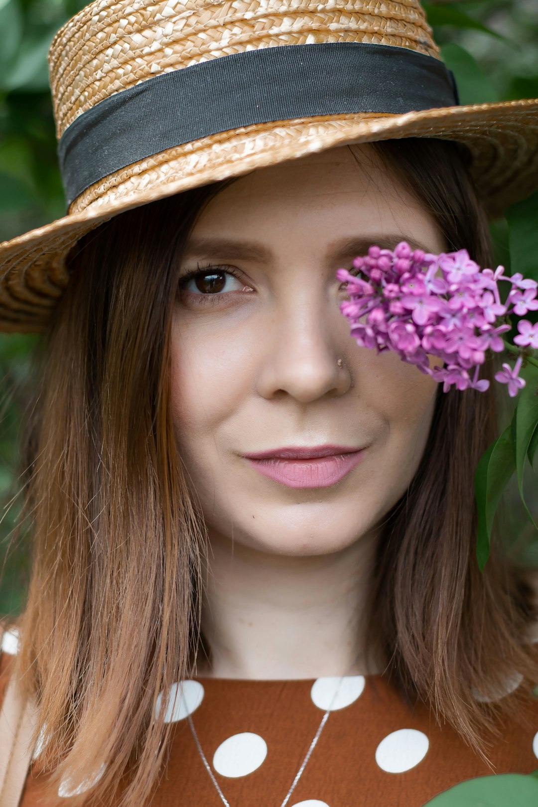 woman in brown hat with purple flowers on her head