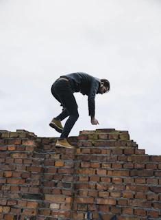 a man standing on top of a brick wall