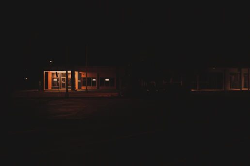 Security guard attentively monitoring a building entrance at night.