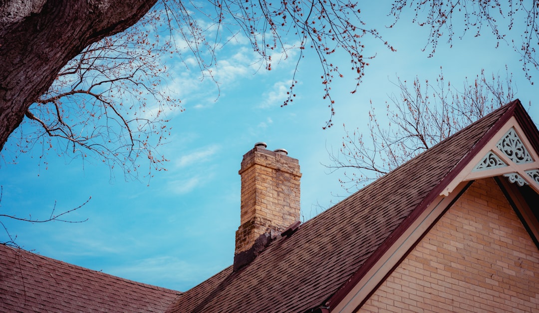  brown brick building under blue sky during daytime chimney