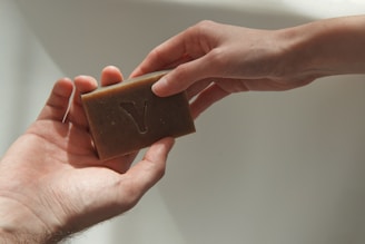 person holding brown wooden box