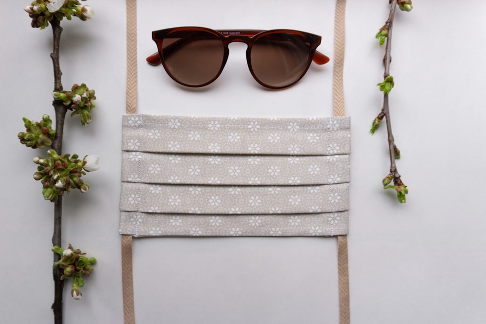 black framed sunglasses on white and blue floral textile