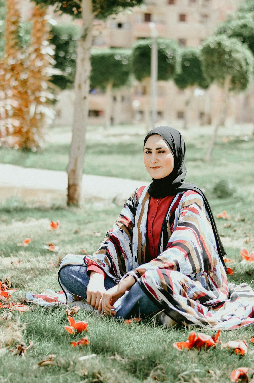 woman in black hijab sitting on ground during daytime