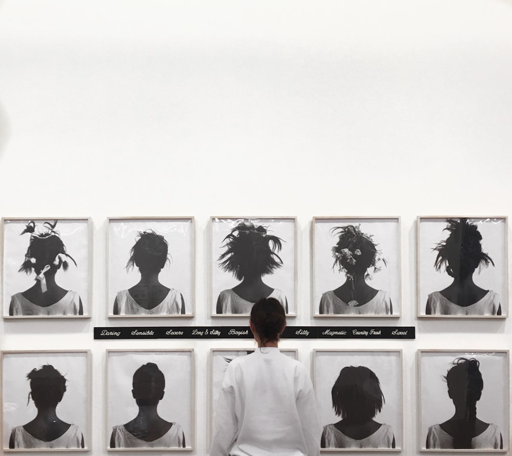 man in white shirt standing in front of photos