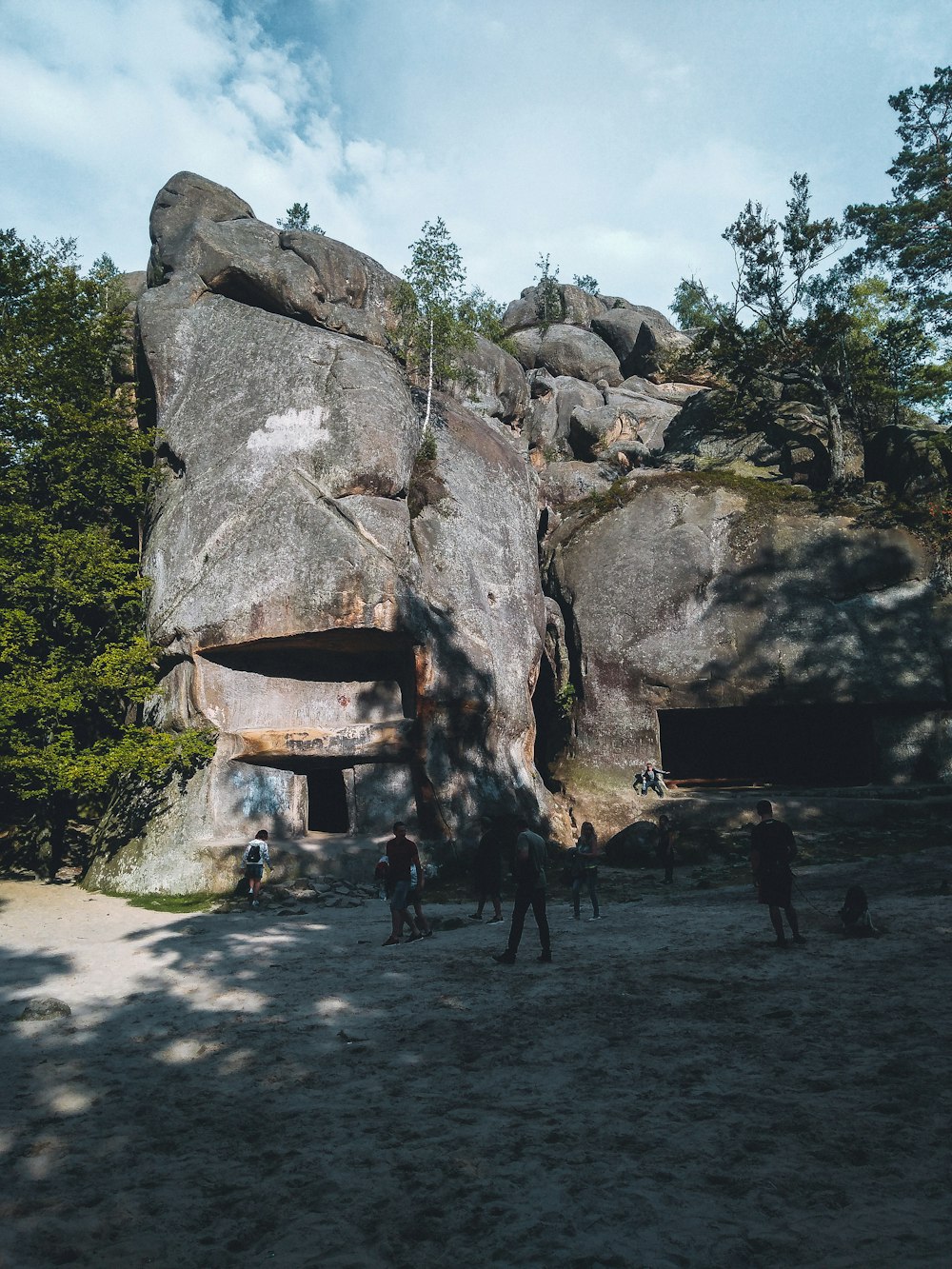 people standing near brown rock formation during daytime