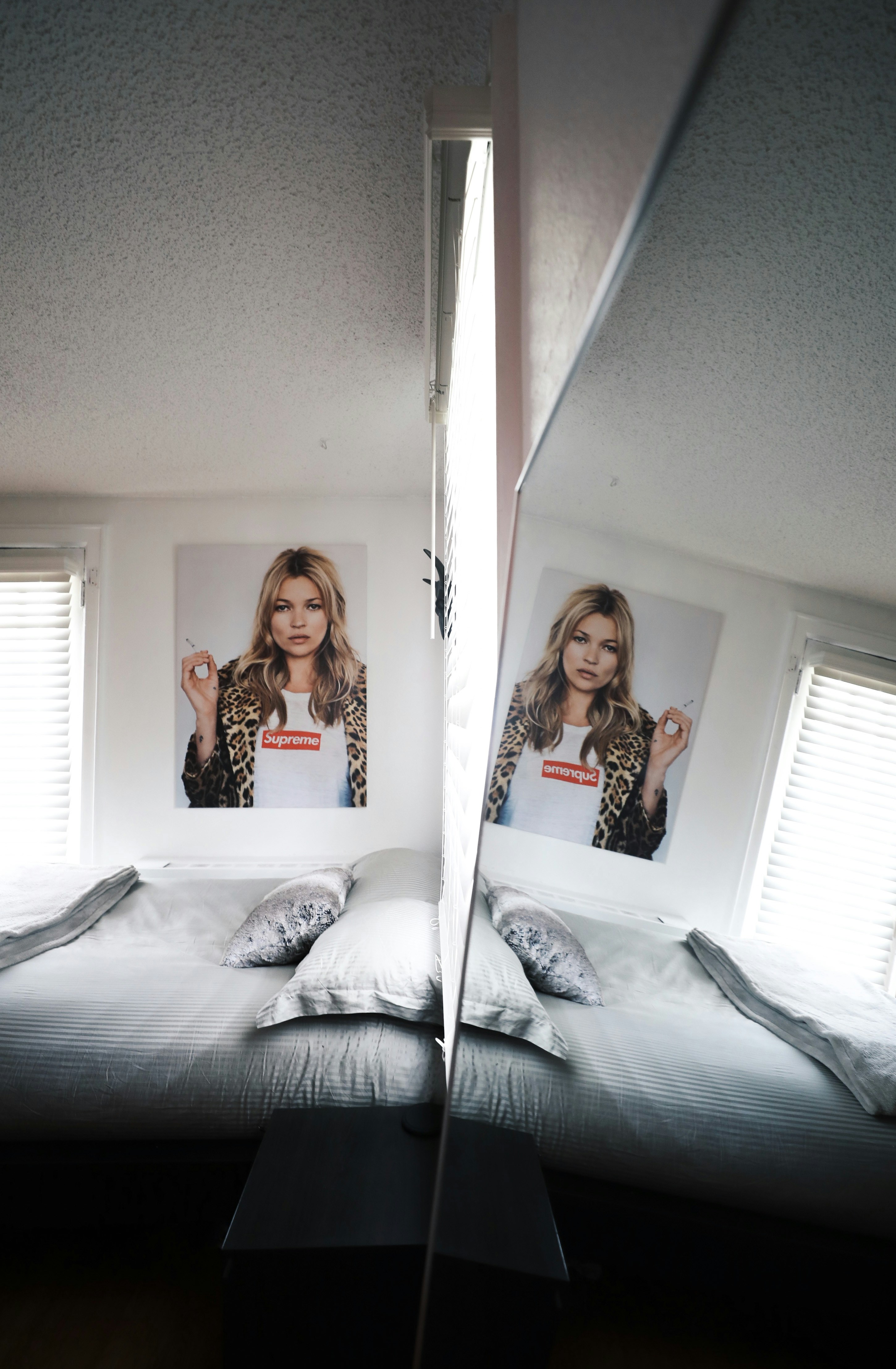 Frau in rot-schwarzem Blumenkleid sitzt auf dem Bett