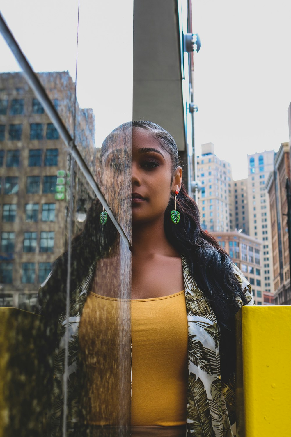 a woman standing in front of a glass wall