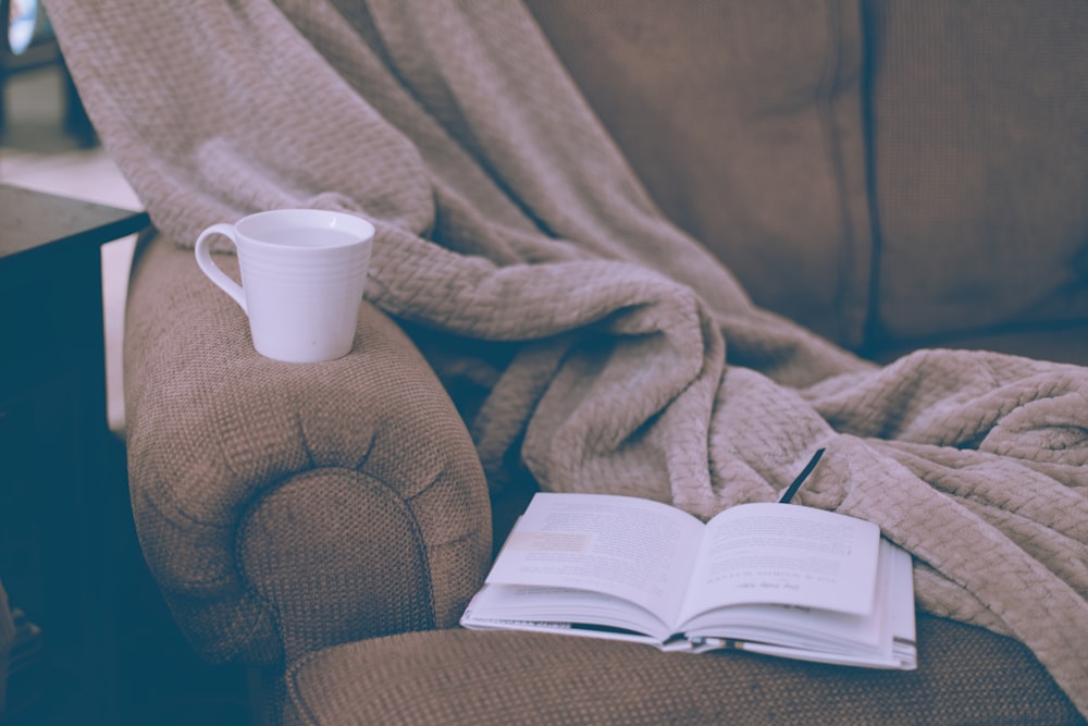 white ceramic mug on book page