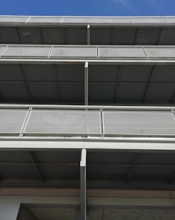 Wide shot of a building facade featuring stainless steel and glass railings on multiple floors.