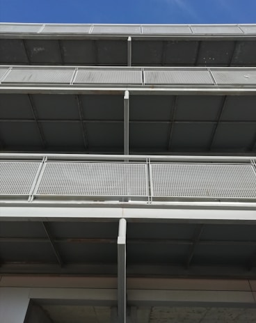 Wide shot of a building facade featuring stainless steel and glass railings on multiple floors.