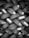 A tightly packed arrangement of new tires, each with distinct tread patterns and labels. The tires are stacked in an overlapping, lattice-like formation, creating an intricate visual texture.
