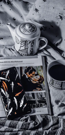 A cozy bedside table with a cup of tea, a book, and the app open on a smartphone screen.