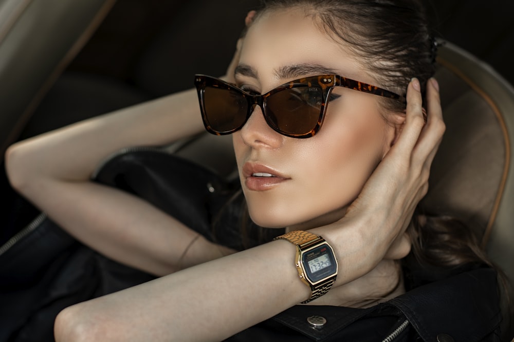 a woman wearing sunglasses sitting in a car