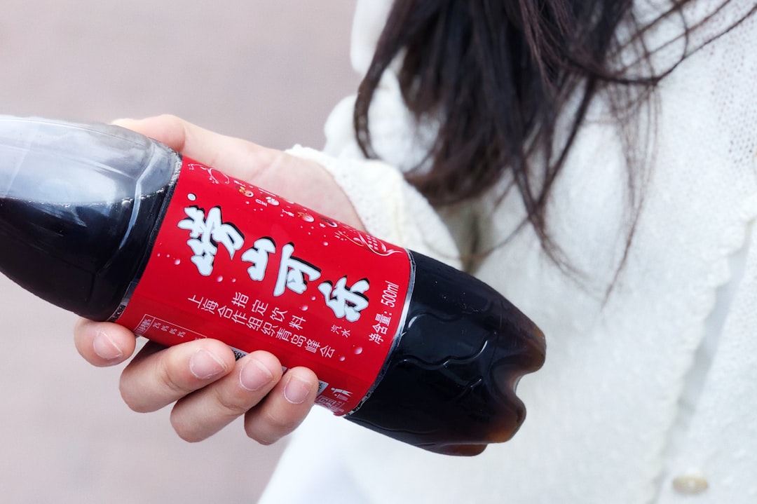 woman holding red labeled bottle