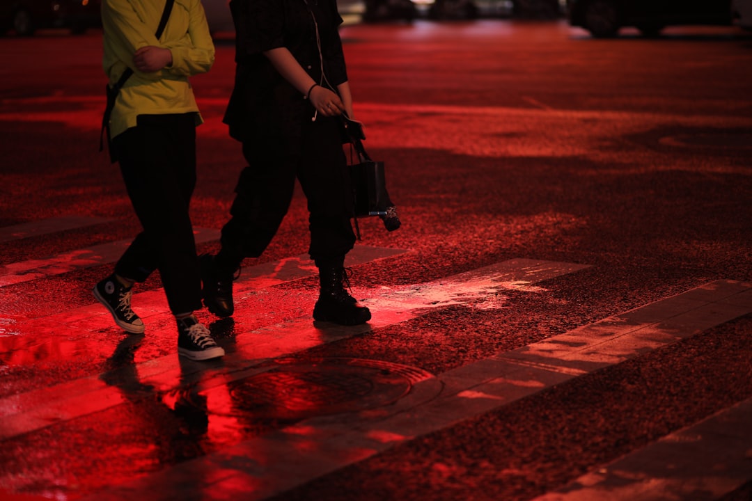 man in yellow shirt and black pants standing on red road