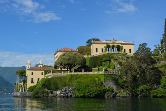 brown concrete building near body of water during daytime in Villa del Balbianello Italy