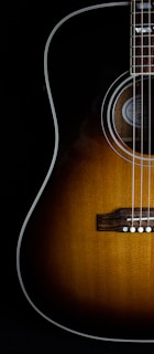 brown acoustic guitar on black background