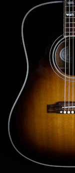 brown acoustic guitar on black background