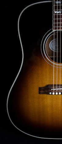 brown acoustic guitar on black background