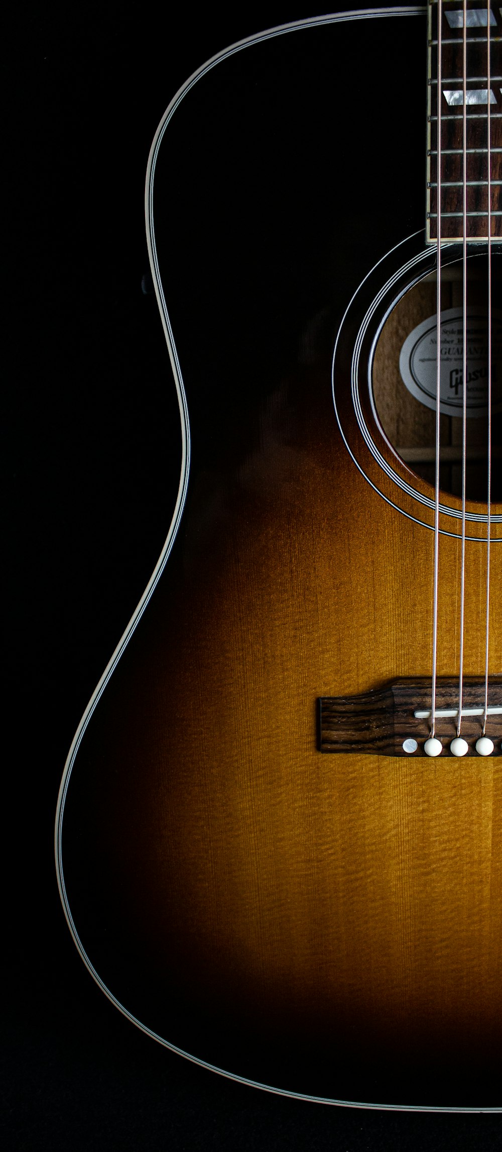 Guitarra acústica marrón sobre fondo negro