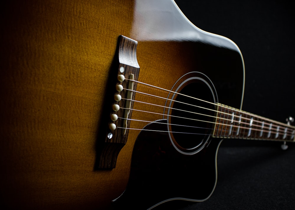 brown acoustic guitar on brown textile