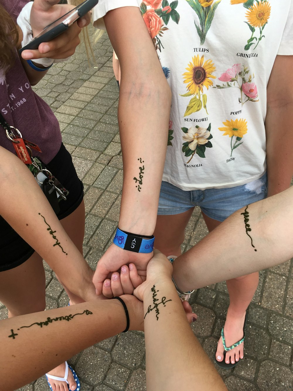 3 women with black tattoo on their hands