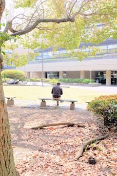 man in black jacket sitting on bench