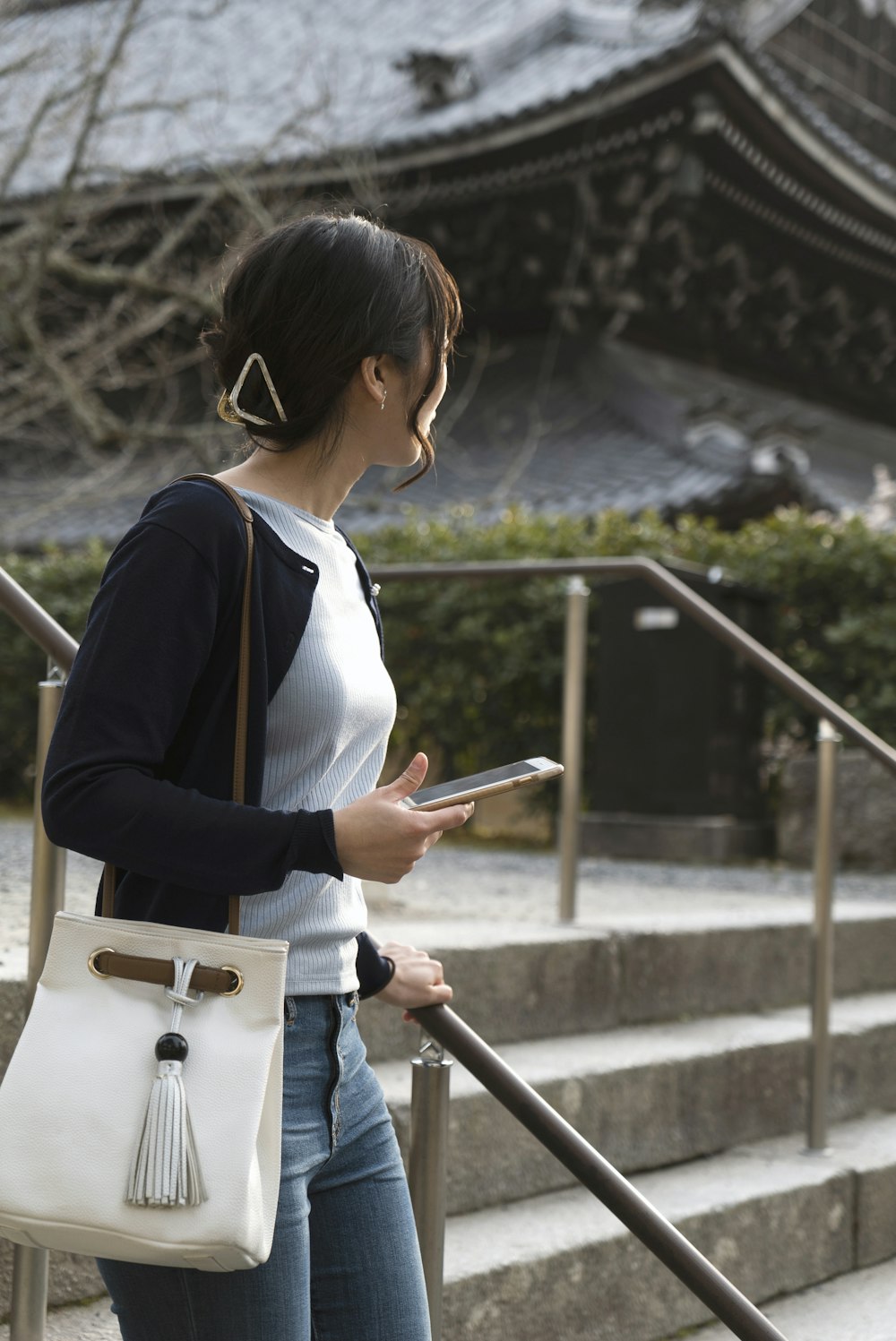 woman in white and blue long sleeve shirt standing on stairs