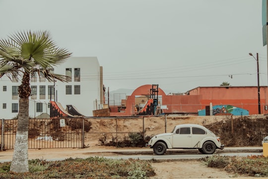 white crew cab pickup truck parked near brown concrete building during daytime in Ensenada Mexico