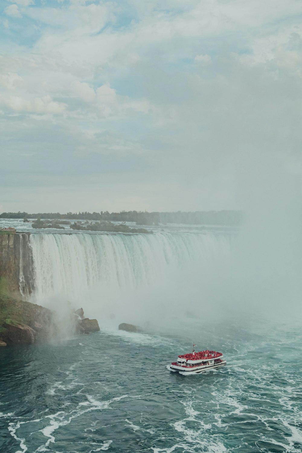 red boat on water falls during daytime